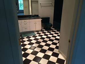 Old bathroom with black and white checkered tiles and blue toilet